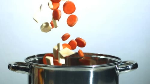 Carottes et panais hachés tombant dans une casserole