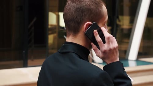Man Talking on Mobile Phone Outside Office Building