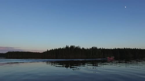 Motorboat sailing on lake at dusk