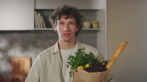 Caucasian Man Standing on Kitchen with Grocery Bag