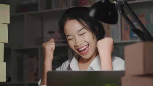Excited Woman Celebrates Business Success at Desk