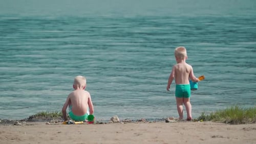 Two Children Play at the Beach in Summer
