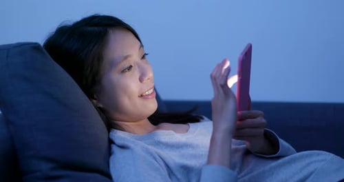 Frau arbeitet nachts am Handy
