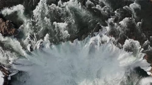 Luftaufnahme des Godafoss-Wasserfalls mit verschneiter Küste und Eis, Island, Winter