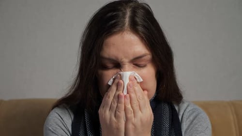 Woman Blowing Nose with Tissue Close Up