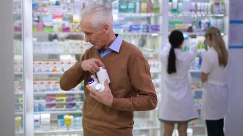 Elderly Man Selecting Medication in Pharmacy