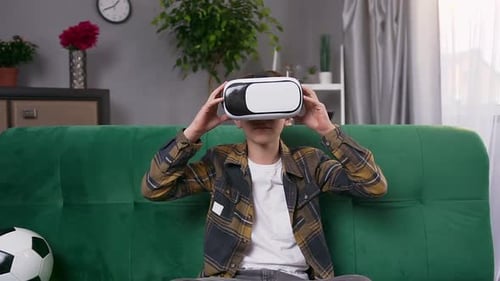 Boy Using VR Headset on Green Couch
