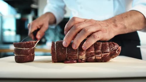 Close-up: The chef cuts the meat of the filet mignon with a knife. The process of preparing food