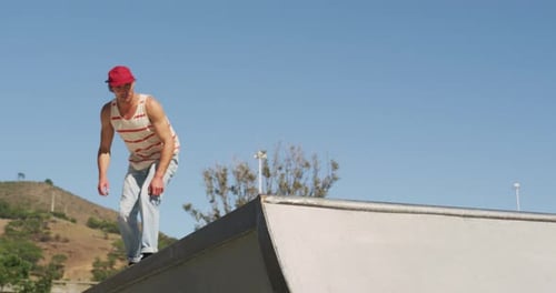 Homme caucasien chevauchant et sautant sur une planche à roulettes par temps ensoleillé