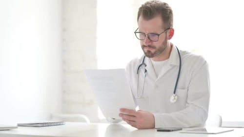 Un médecin célèbre le succès lors de la lecture de documents au bureau