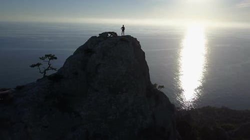 Happy Young Woman Stands on the Top of High Mountain Observing Wonderful Seascape