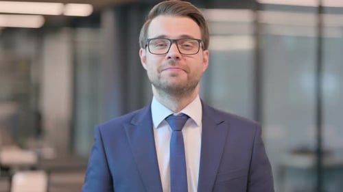 Smiling Businessman Looking at Camera in Office