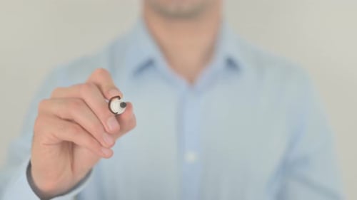 Adult Completes Writing on Glass Surface