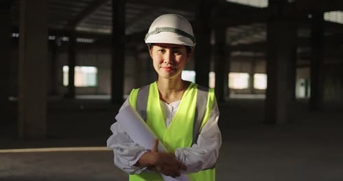 Asian Industrial Engineer Woman In Hard Hat Wearing Safety Jacket Working In Construction Site.