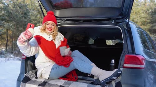 Woman Sits in Car Trunk Enjoying Winter