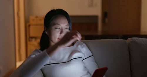 Woman Using Smartphone Looks Tired on Couch