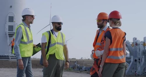 Engineers Inspecting Construction Site Near Windmill