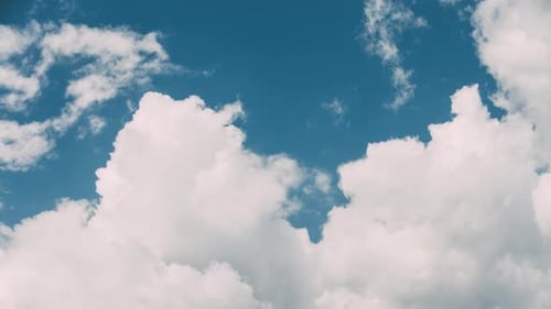 Fluffy White Clouds Moving Across the Blue Sky