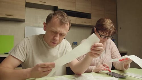 Family in the Evening in the Kitchen Checking Expenses Family Budget Crisis