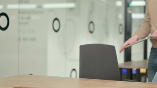 Young Adult Opens Laptop in Modern Office