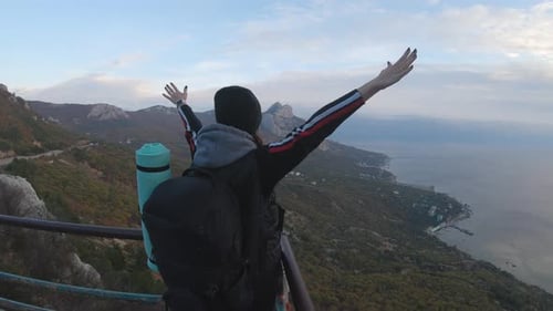 Person Reaches Top of Mountain Overlooking Ocean