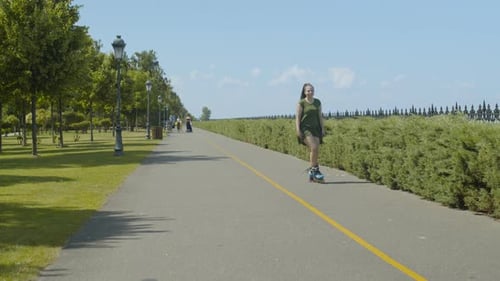 Woman Inline Skating on Paved Path on Sunny Day