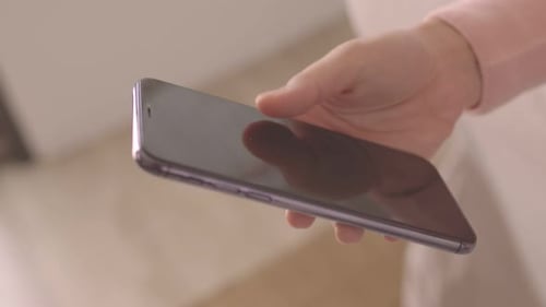 Hand Holding Modern Smartphone Indoors Close Up