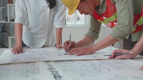 Asian Engineers With Helmets Drawing Building Construction For A Man At The Office