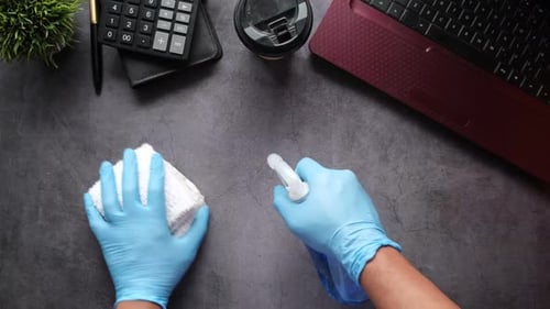 Disinfecting a Desk with Gloves and Spray