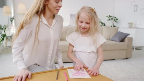 Girl Gifts Hand-Drawn Card to Mother at Home