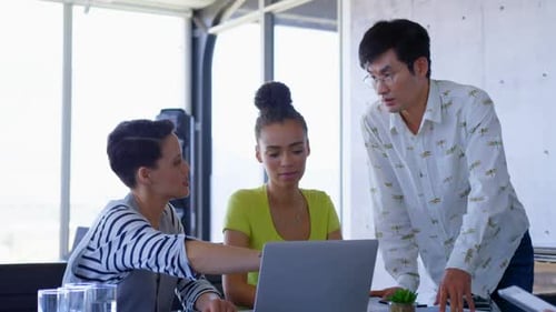 Muti-ethnic business colleagues discussing over laptop in a meeting at modern office 4k