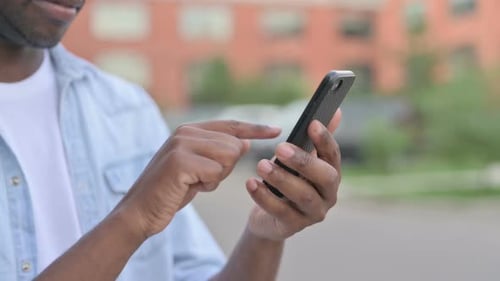 Close Up of African Man Using Smartphone Outdoor
