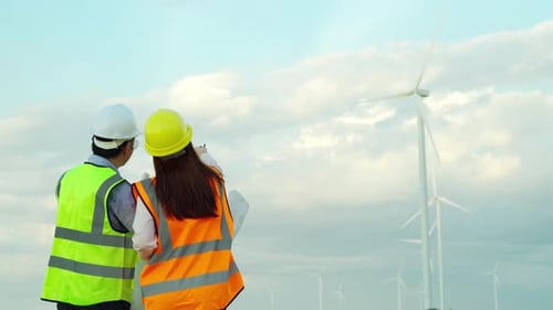 engineer team analyze a blueprint drawing of wind turbine farm