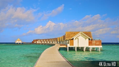 4K Holzbrücke führt in Zeitlupe zu Overwater-Bungalows auf einem Resort auf den Malediven