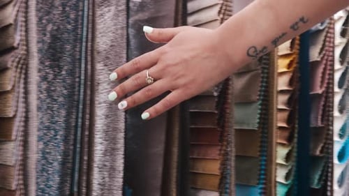 Hand Touches Fabrics in Interior Design Shop