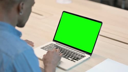 Man Using Laptop with Green Chroma Key Screen