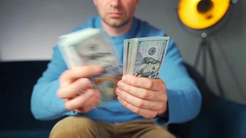 Adult Counting Stack of Cash Money at Home