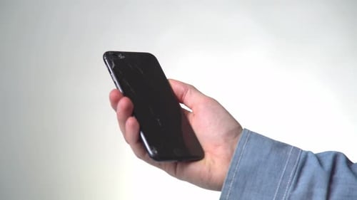 Concept of Smart Phone with Broken Screen. Top View of Man Hands Holding a Phone with Cracked