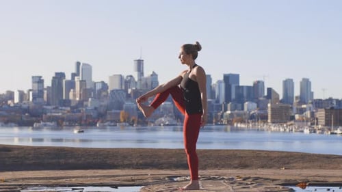 Woman Practices Yoga Pose City Skyline Backdrop