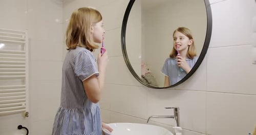 Girl Brushing Teeth in a Bright Modern Bathroom