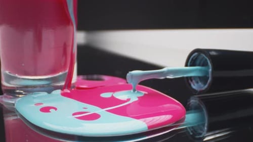 Rosa und blauer Nagellack auf schwarzem Hintergrund