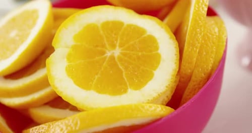 Vibrant Orange Slices in a Pink Bowl