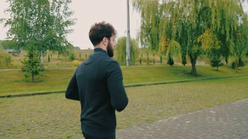 Bearded Man Jogging in Urban Park in Daytime