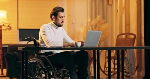 A Young Disabled Bearded Man Works at Loft Style Home He Sits in a Wheelchair