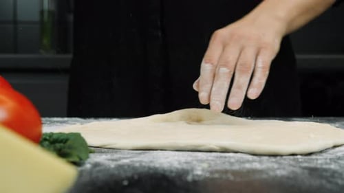 Hands Stretching Dough for Pizza Preparation