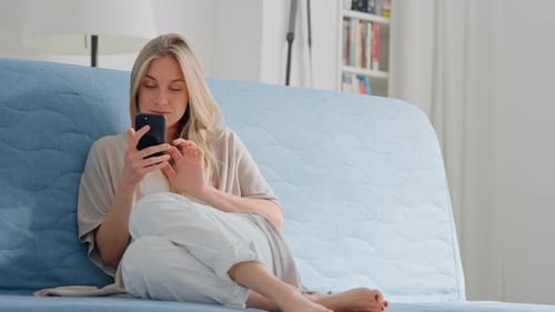 Woman Relaxing on Couch with Smartphone