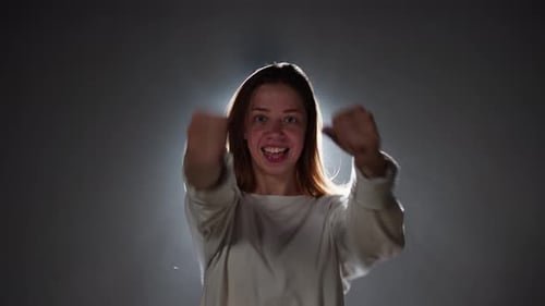 Mujer talentosa bailando hip hop en segundo plano con luz blanca en estudio