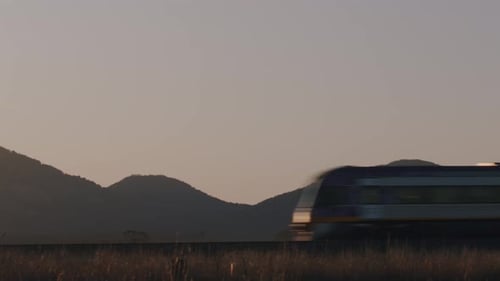 Zug fährt an Bergen vorbei Filmaufnahme mit Sonnenuntergang und Landschaft