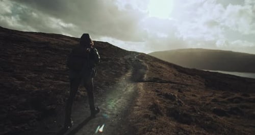Two people walk together on hillside