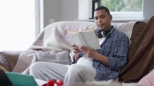 Man Relaxing on Couch Reading a Book